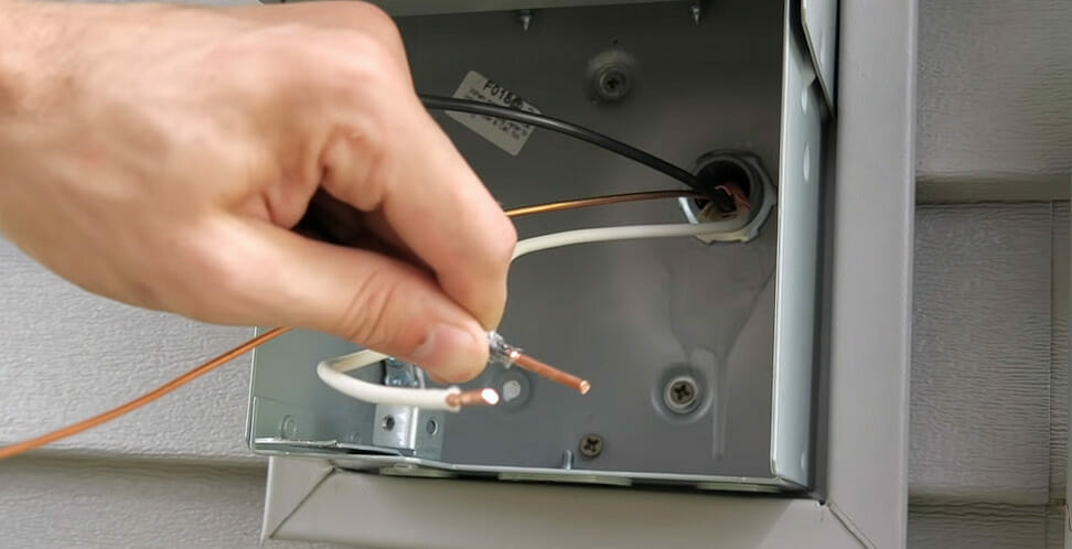 A person showing a stripped wire for an RV plug