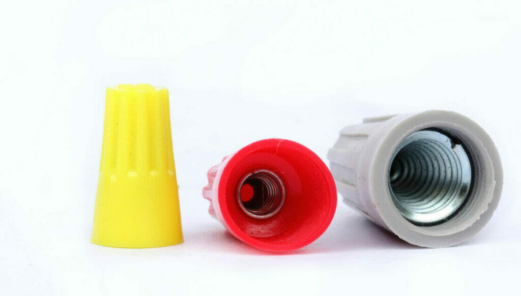Yellow, red, and grey wire nuts on a white background