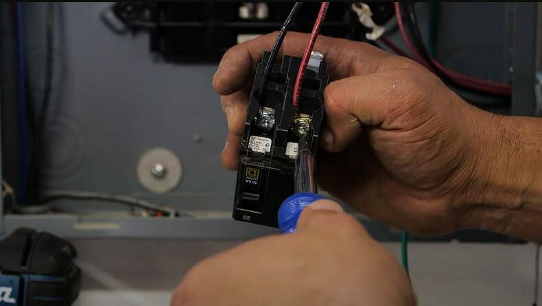 A person is wiring a circuit breaker for a 220 outlet
