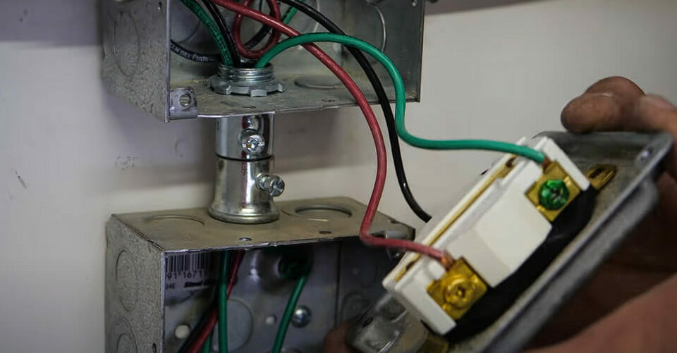 A person connecting the circuit wires to a new 220 outlet