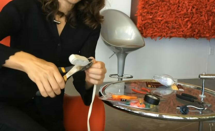 A woman is stripping a wire