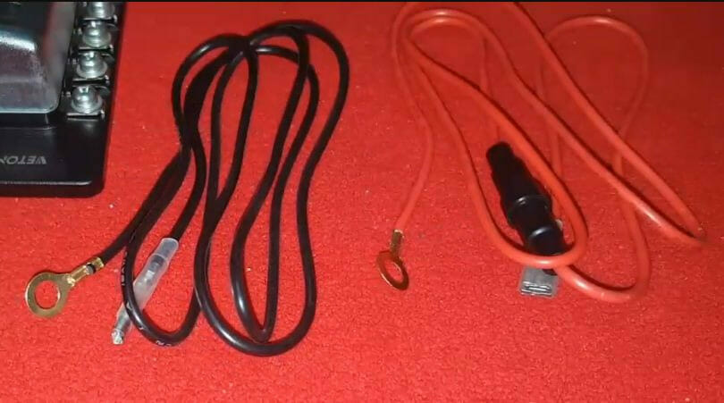 A pair of red and black wires on a red table