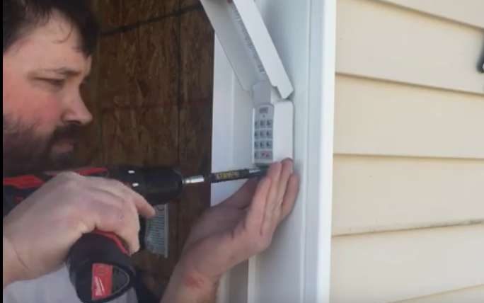 A man is using a drill to open a door