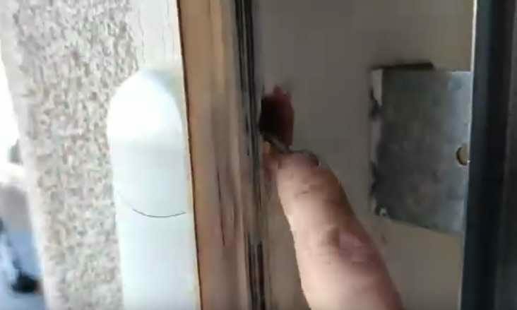 A person putting a finger on a door handle