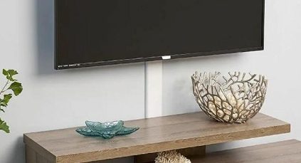 A wall-mounted flat screen TV with hidden wires on a wooden shelf