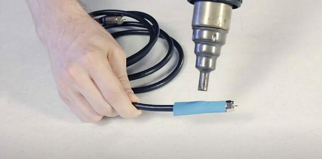 man performing heat shrink tubing on a wire
