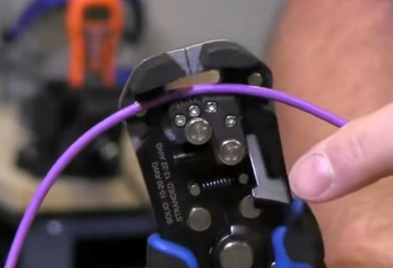 placing the wire into position inside an automatic wire stripper
