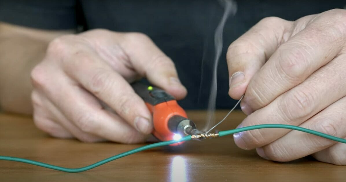 A person soldering two wires together