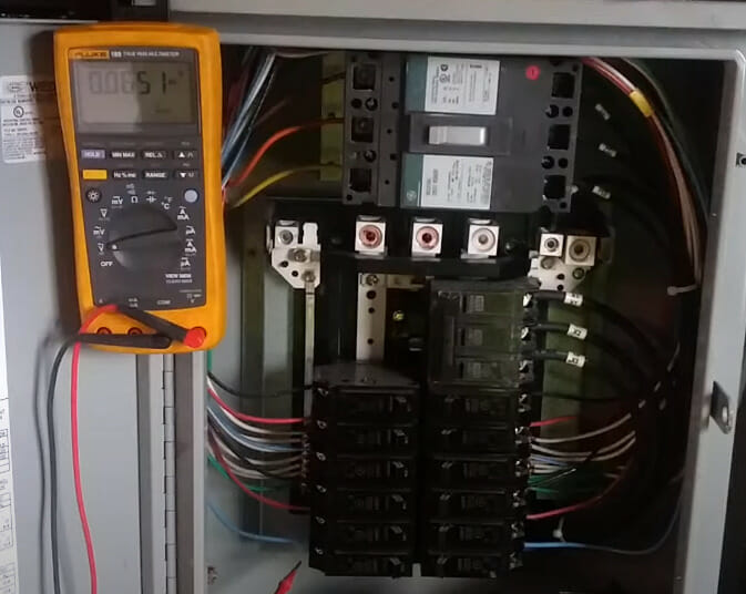 A multimeter to test a circuit breaker in a main electrical panel