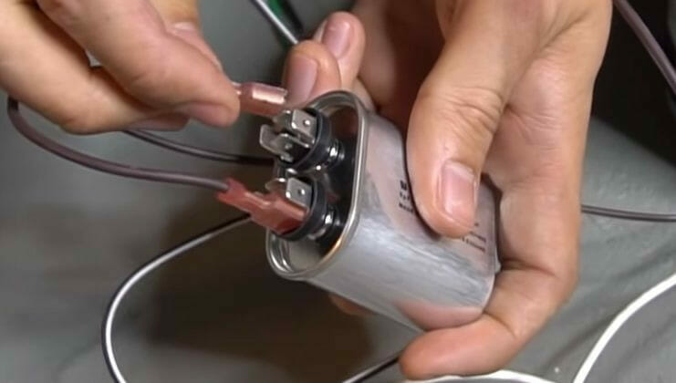 A person is connecting wires from a blower motor to a plug