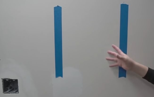 A person marking the with blue tape