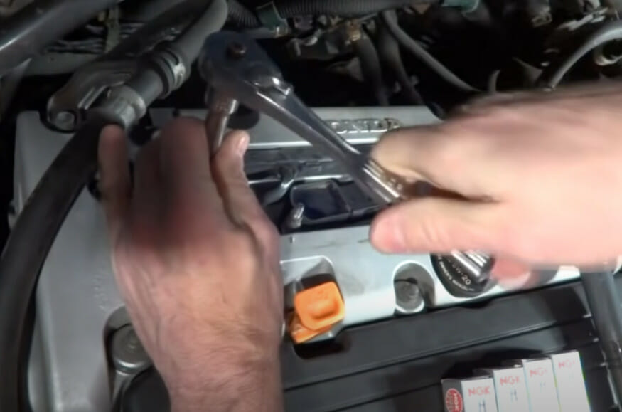 A person working on the car engine with wrench tool