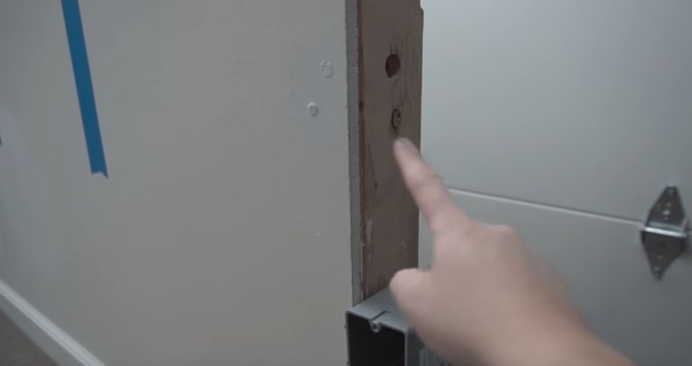 A person pointing at the hole on the stud