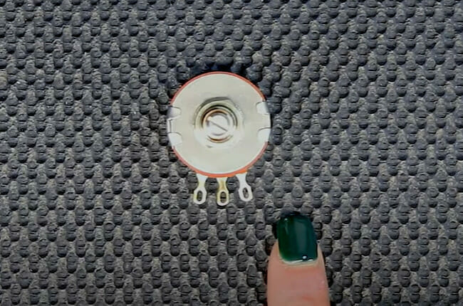 A woman's finger is pointing at a potentiometer