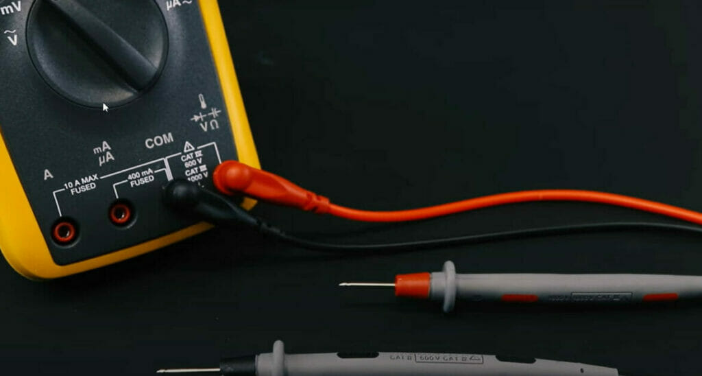 A multimeter connected to its wire placed in a black background
