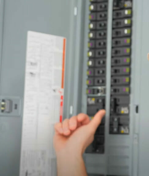 A person turning off a breaker in a main circuit panel