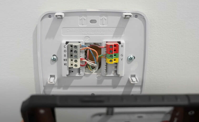 An opened Honeywell thermostat showing its wires