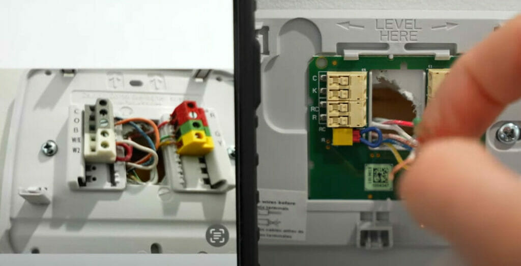 A person is demonstrating how to wire a Honeywell thermostat