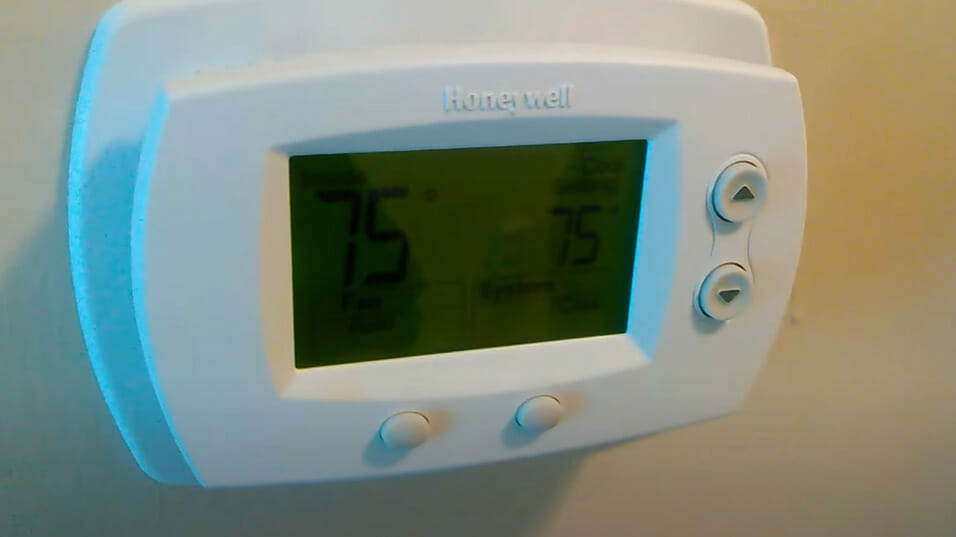 A Honeywell thermostat on the wall showing 75 degree temperature