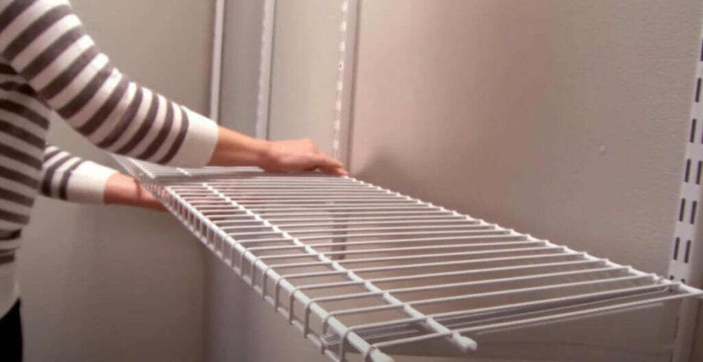 A woman demonstrates the steps of hanging wire shelves in a closet