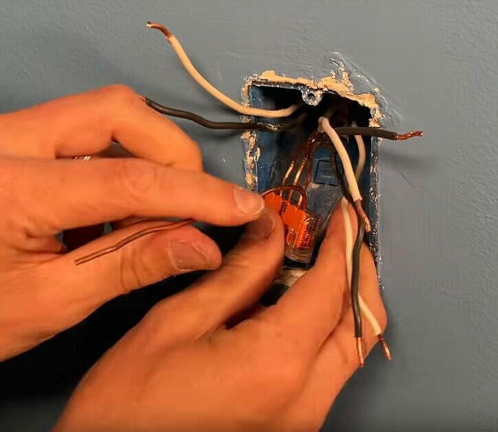 A person connecting all the ground wires together