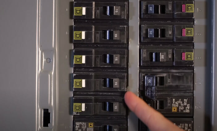A person pointing at circuit breaker