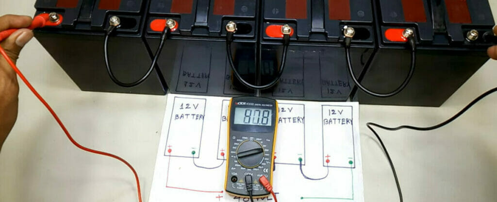 A person is using a multimeter to check the voltage of a battery of a 4 series battery