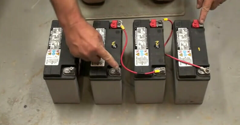 A person wiring a 4 battery in a series