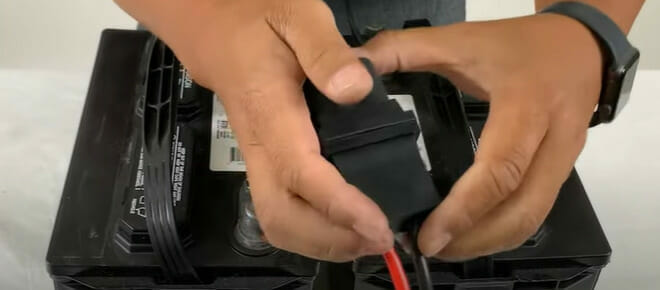 A person holding a connection chain for a battery in series