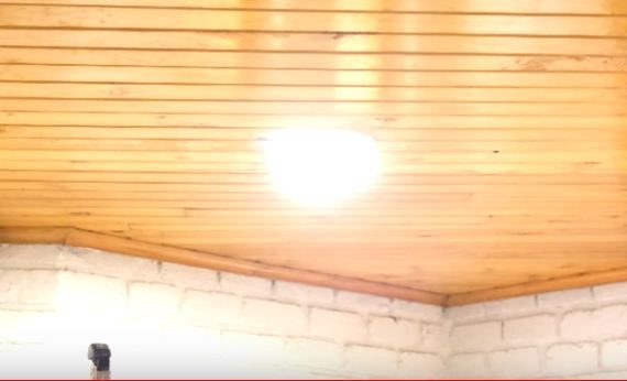 A wooden ceiling with a LED light mounted in it