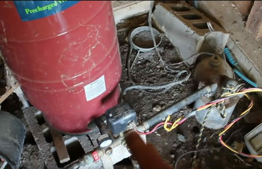 A person is wiring a well pump to a generator in a house