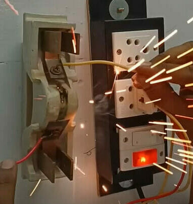 A person connecting a wire to a terminal and experiencing a fire spark