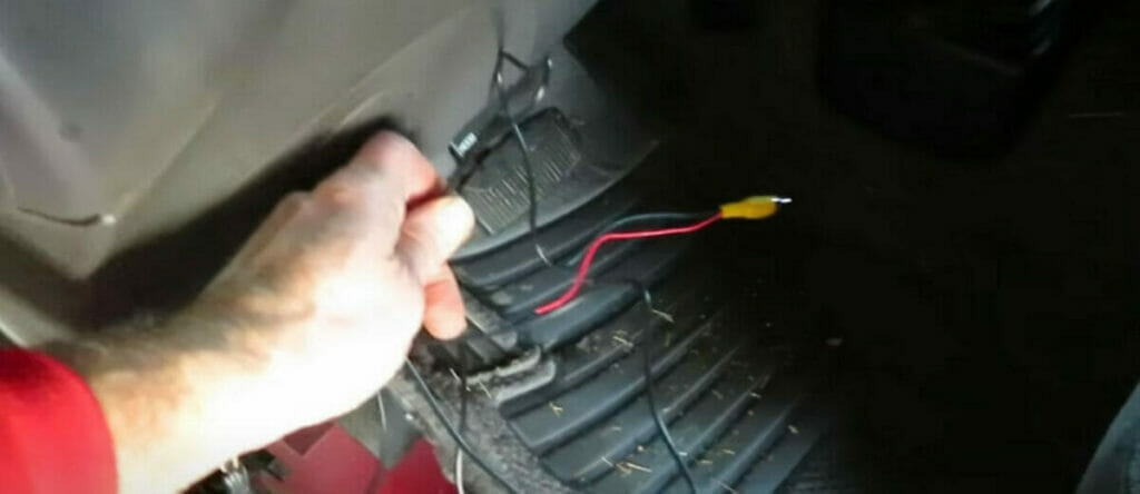 A person running the wire from the mounting spot to the dashboard