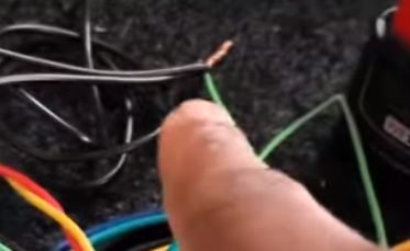 A person pointing the ground wire on the floor
