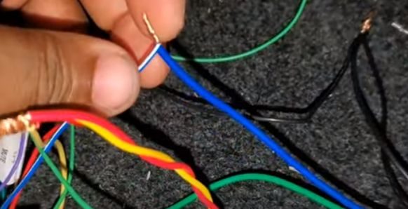 A person connecting blue(+) wire to the blue wire of DVD player