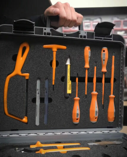A person is holding a tool case full of tools