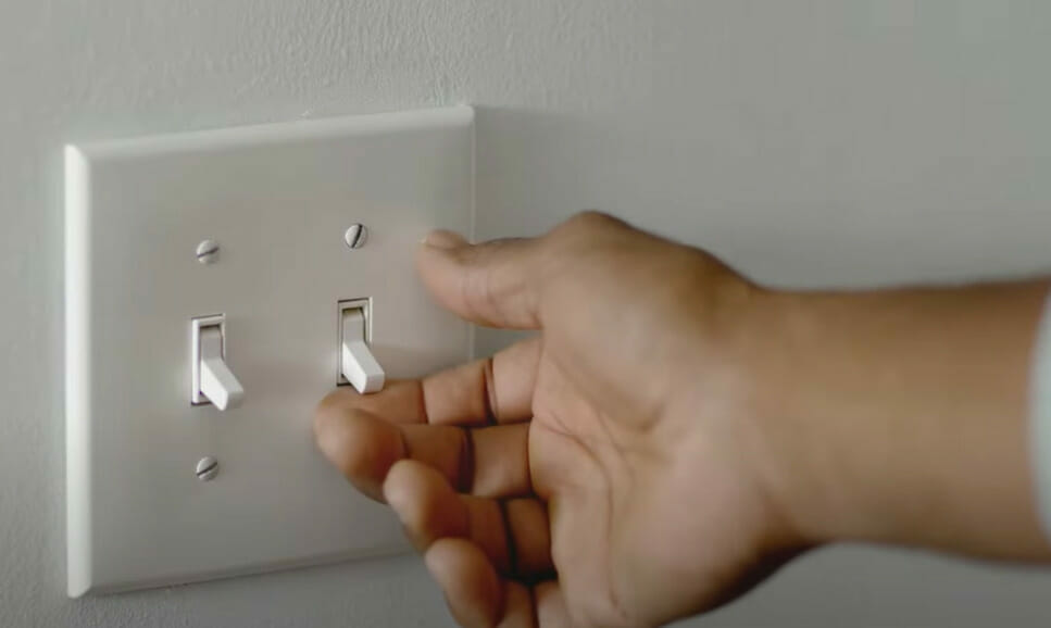 A person turning on a light switch
