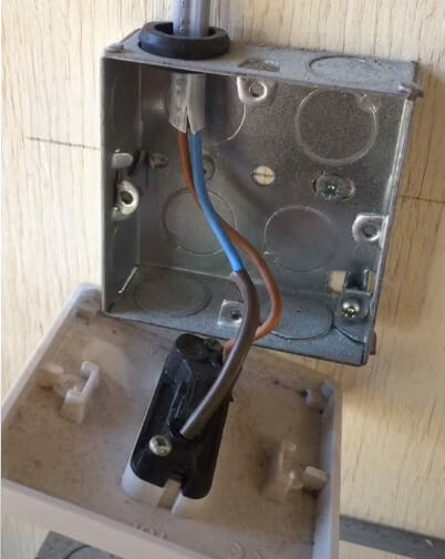 An undone light switch metal box