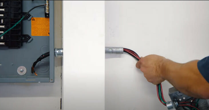 A person passing the wire of a break through the wall