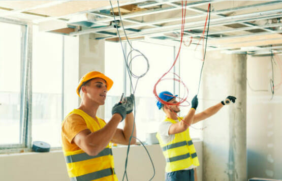 Two construction workers holding TFFN wires