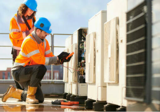 Two men using applications to work on an air conditioning unit