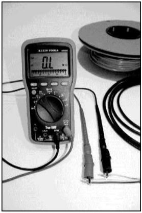 A black and white image of a multimeter and rolled wires