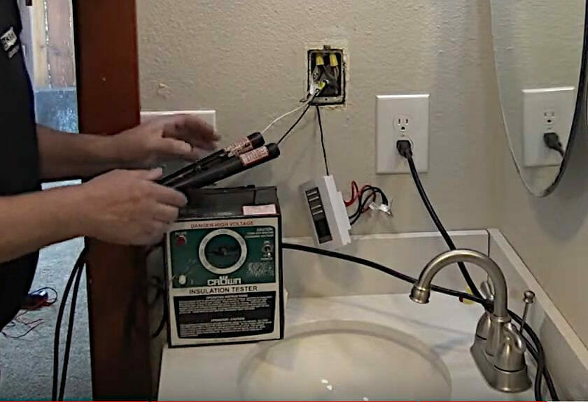 A person uses a higher voltage insulation tester to check the thermostat wirings