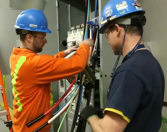 Electricians working on an electrical panel while utilizing Simpull Wire