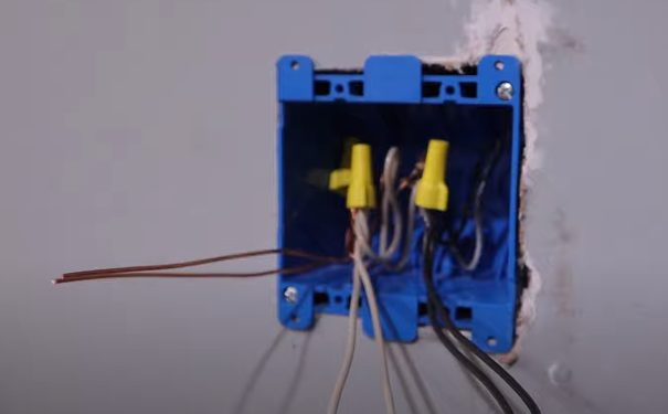 A blue box with capped and uncapped wires in it
