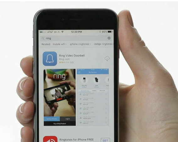 A person is holding up a phone with a doorbell app