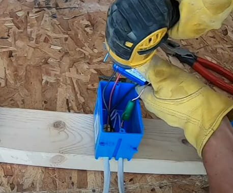 A person is attaching the switch with the screw and pliers