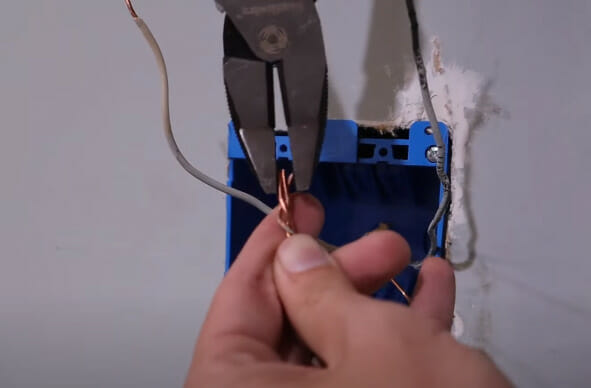 A person twisting wires and joining them together using a plier