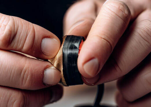A person putting electrical tape on the wire
