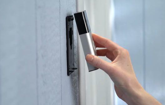 A woman stripping the Ring doorbell on the wall with the strip plate